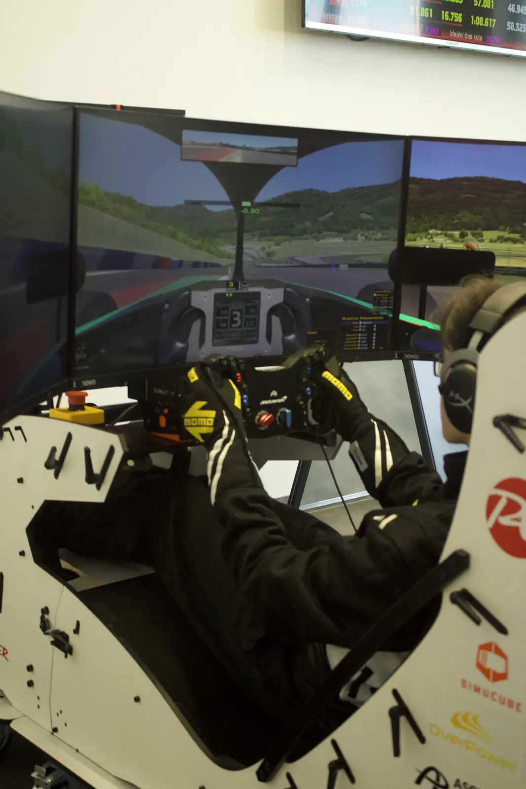 Oliver driving on a triple-screen simulator rig